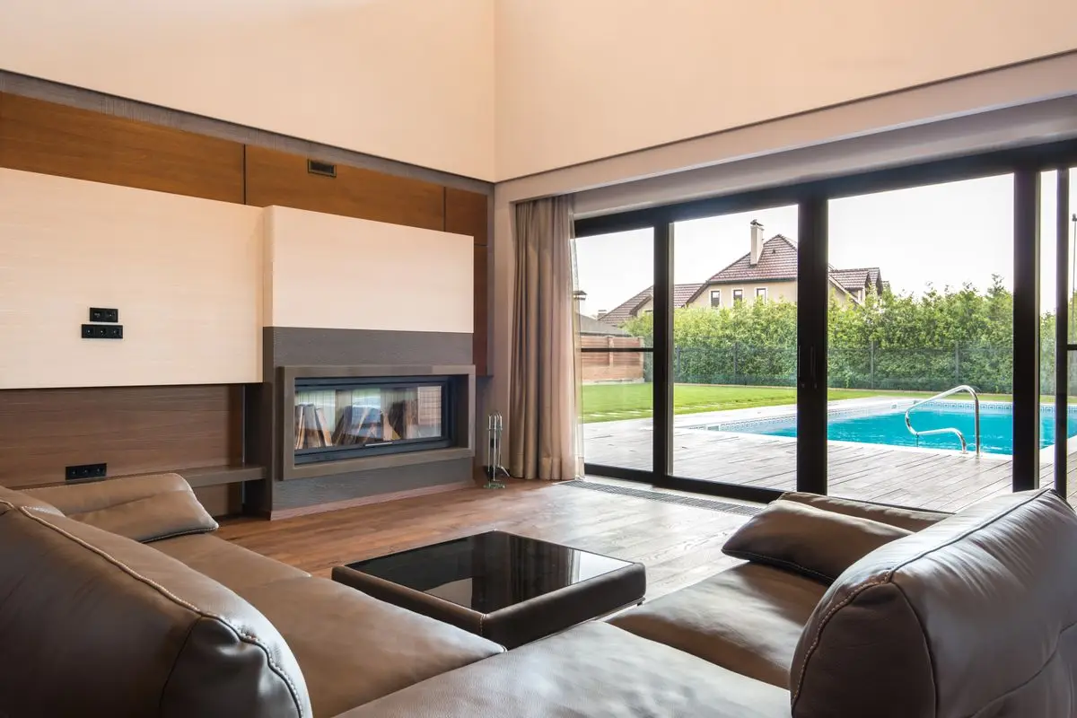 Sliding glass doors opening from a modern home to the pool
